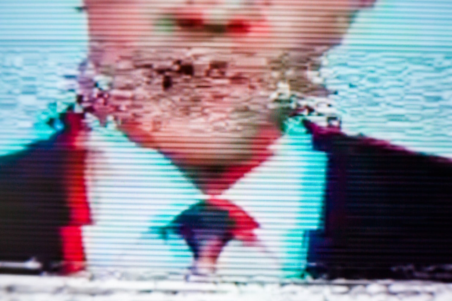 Digitally influenced speech illustrated by an image of a man on a screen with image distortion over his mouth.